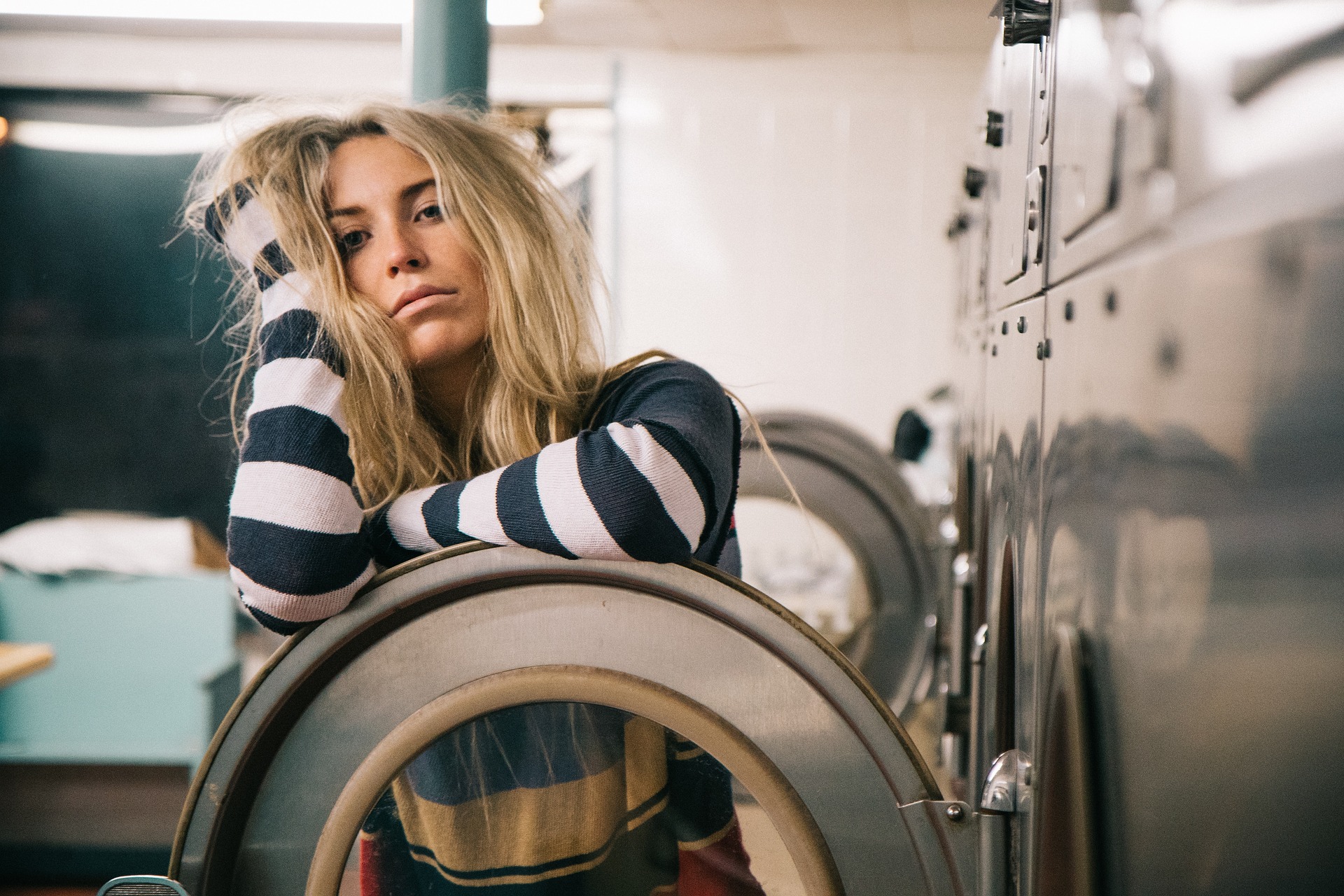 Girl at laundry mat looking tired